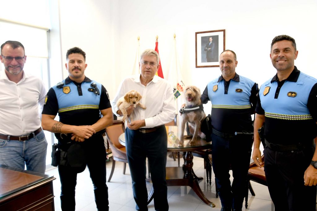 El alcalde. con la cachorra Moka y junto a la perra Peka, con el oficial y el agente de la unidad canina, el comisario jefe y el concejal de Seguridad y Emergencias